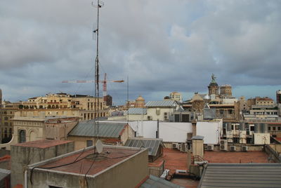 Buildings in city against cloudy sky