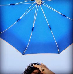 Low angle view of woman against umbrella