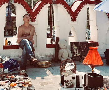 Portrait of young man sitting on sculpture