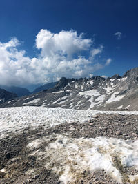 Scenic view of snowcapped mountains against blue sky