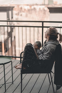 Side view of woman sitting on bench