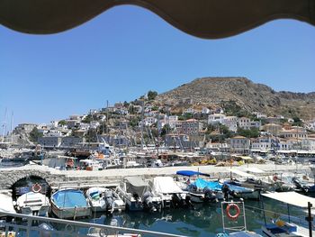 Sailboats moored at harbor against clear blue sky