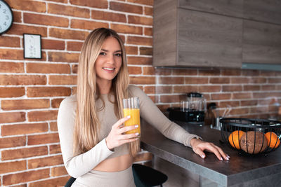 Portrait of a smiling young woman drinking glass