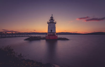 Lighthouse at seaside during sunset