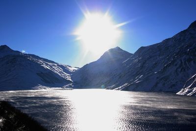 Scenic view of snowcapped mountains against sky on sunny day