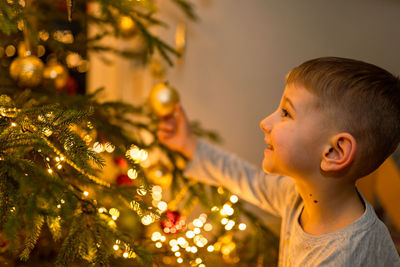 Boy looks at the christmas tree 