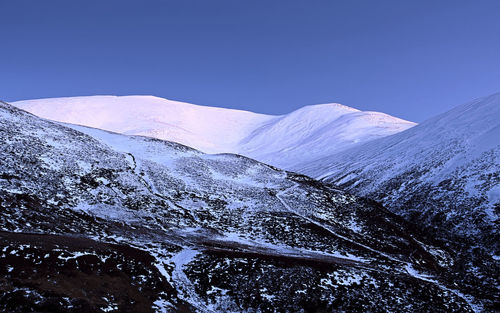 Scenic view of snow covered mountains against clear sky