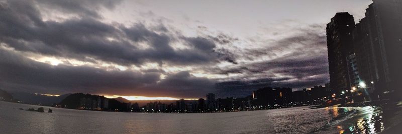 Buildings in city against cloudy sky