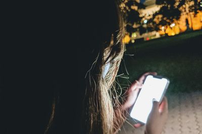 Midsection of woman using mobile phone outdoors