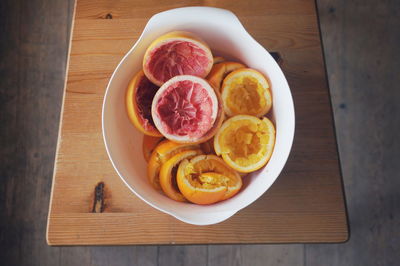 High angle view of sliced citrus fruits in bowl on cutting board
