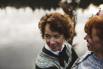 Happy lesbian couple laughing at lakeshore