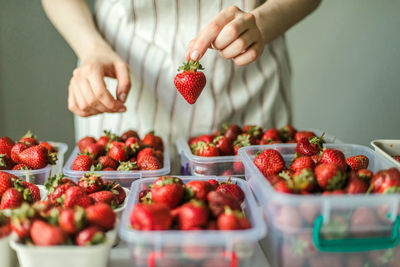 Midsection of woman holding strawberries