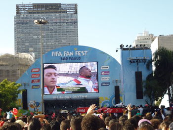 Crowd in city against sky