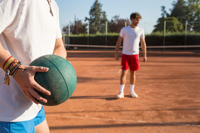 Tennis players exercising with medicine ball at court