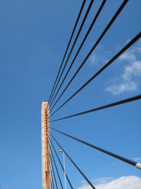 Low angle view of suspension bridge against clear blue sky