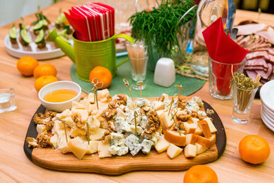 Wooden board with pieces of cheese, honey, walnuts. mold cheese gorgonzola, parmesan, smoked cheese