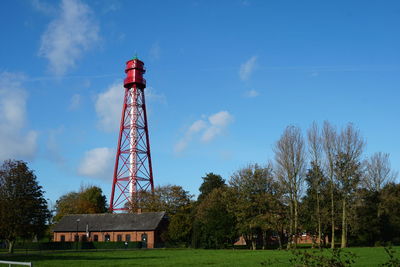 Low angle view of tower on field against sky