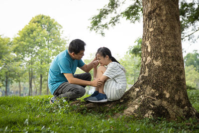 Young couple sitting on tree trunk