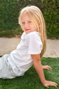 Portrait of cute girl sitting on field