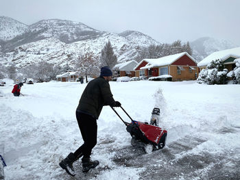 Rear view of people on snowcapped mountains during winter