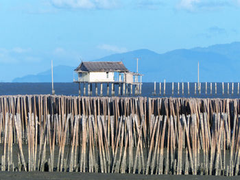 House on pier by sea against sky