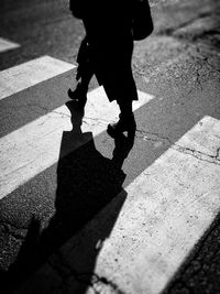 Low section of man walking on sunny day