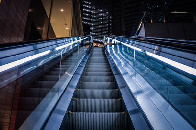 Low angle view of escalator in illuminated building