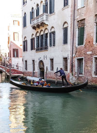 Boats in canal along buildings