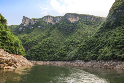 Scenic view of lake by mountains against sky