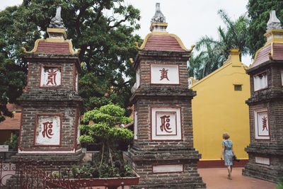 Rear view full length of woman walking outside temple