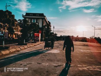 Full length of man walking on street against buildings in city