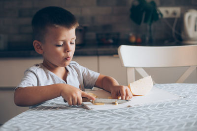 Boy looking at table at home