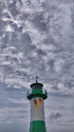 Low angle view of lighthouse by building against sky