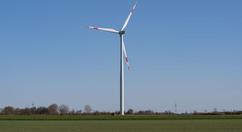 Windmill on field against clear sky