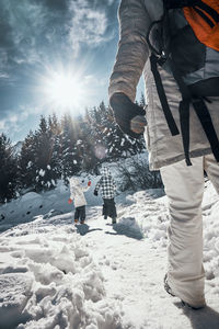 Low section of people standing on snow covered landscape