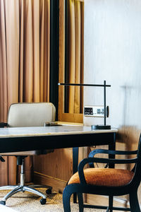 Empty chairs and table against wall at home