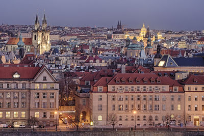 View of illuminated buildings in city of prague at dusk