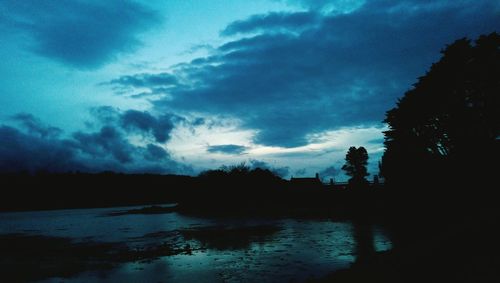 Silhouette of trees against cloudy sky