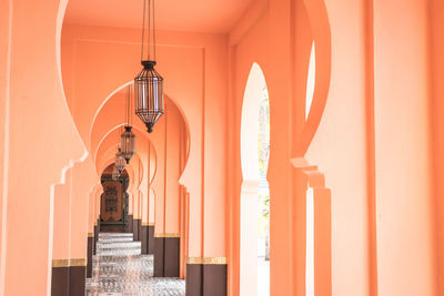 Low angle view of illuminated lights hanging from ceiling in building corridor