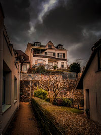 Footpath amidst buildings against sky