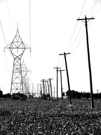 Low angle view of electricity pylon on field against sky