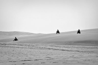People riding motorcycle on desert