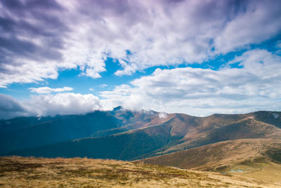 Scenic view of mountains against cloudy sky