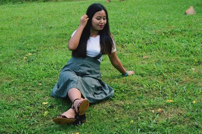 Young woman sitting on field