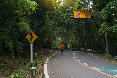 Road sign against trees