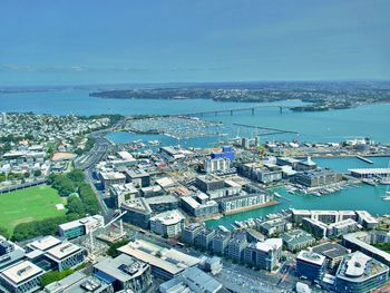 High angle view of buildings by sea against blue sky