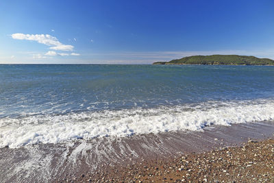 Scenic view of sea against blue sky