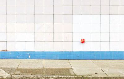 Red umbrella on wall by swimming pool