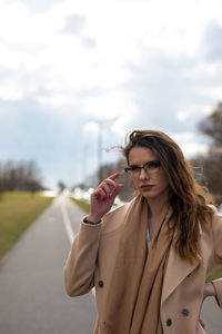 Beautiful young woman standing against sky