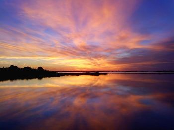 Scenic view of lake against romantic sky at sunset